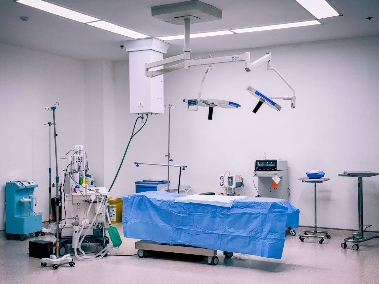 A hospital room filled with various medical equipment, including surgical instruments and monitoring machines.