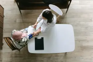 Doctor measuring blood pressure of a patient wearing a headscarf during a cardiology consultation.