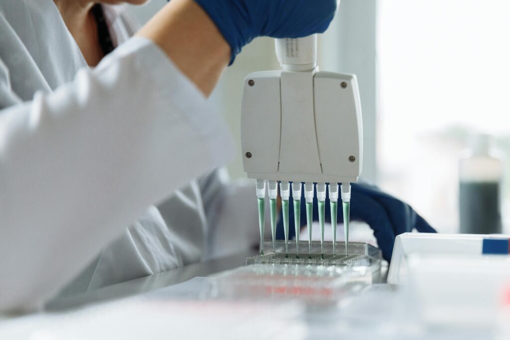 Pathology lab using automated pipettes to analyse fluid samples for medical diagnostics.