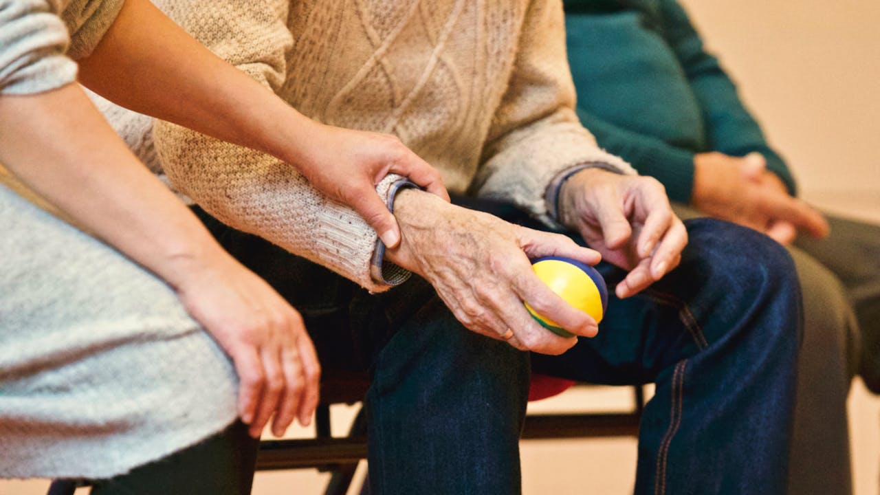 Palliative care nurse supports elderly patient with gentle reassurance during therapy session