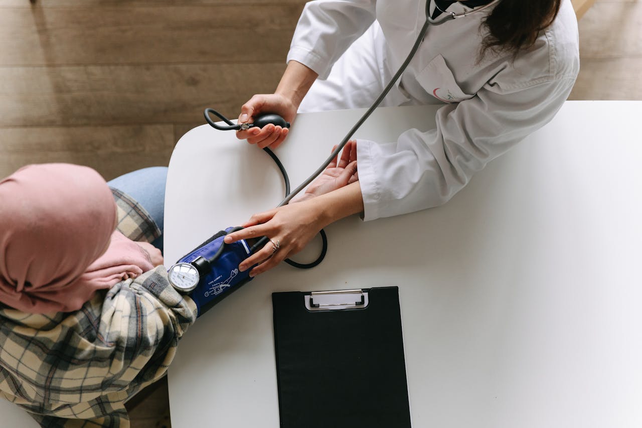 Palliative care specialist checks patient's blood pressure during a routine assessment