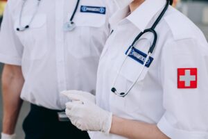 Emergency medicine doctors in uniform wearing stethoscopes and medical gloves during emergency response duty.