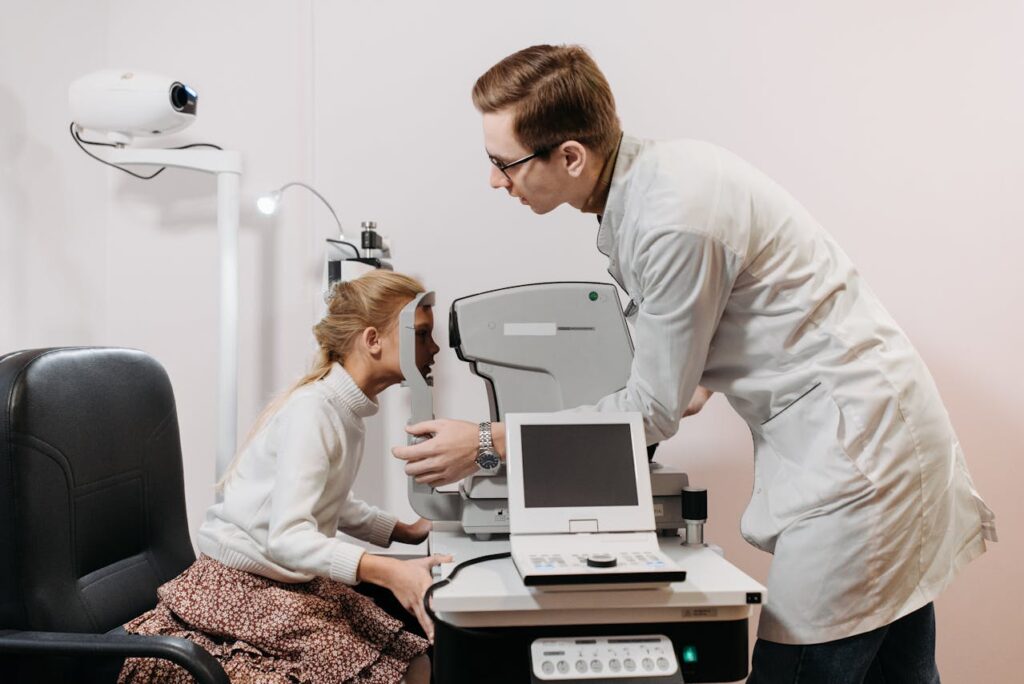 Male ophthalmologist conducting a pediatric eye exam with a modern vision testing device