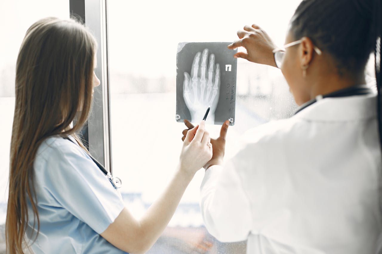 Medical team analysing a hand X-ray image to diagnose a musculoskeletal condition.