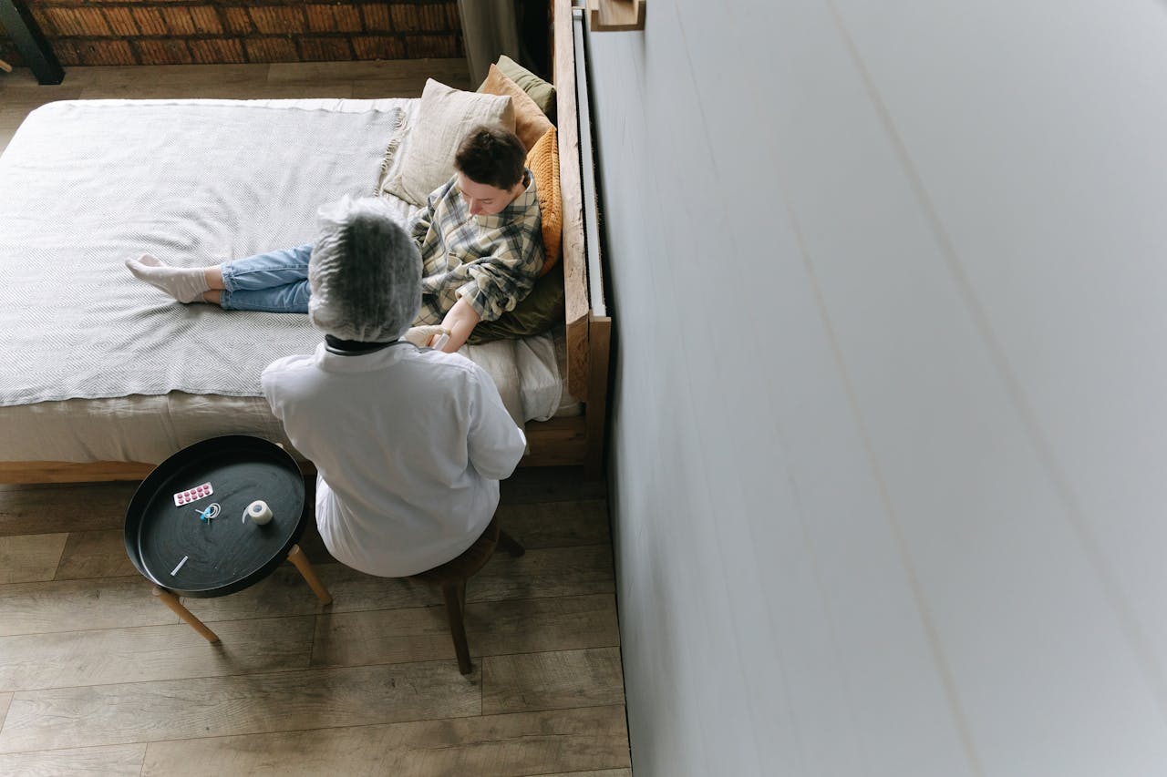 Family medicine doctor providing home healthcare and wound care to a patient in bed.