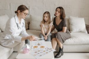 Family physician explaining diabetes care to a mother and child during a medical consultation.