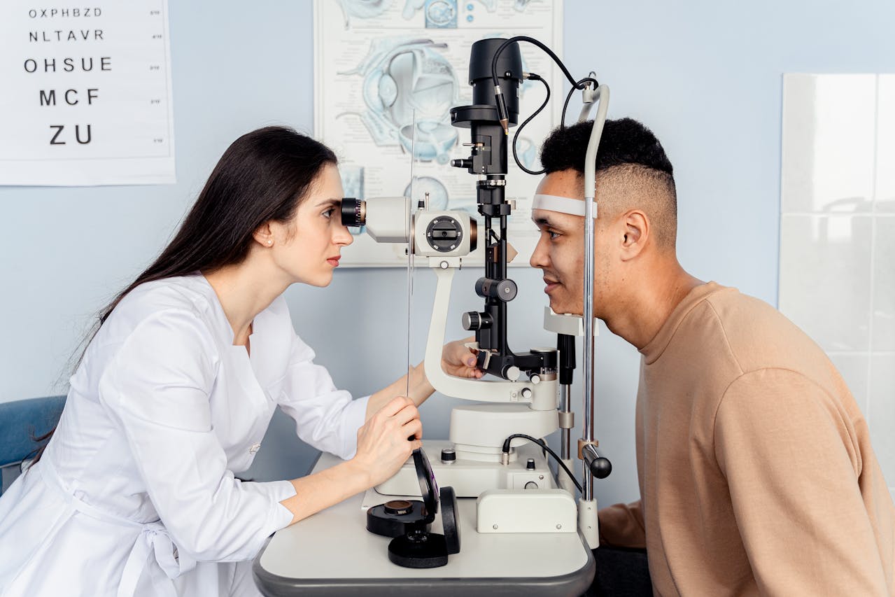 A female ophthalmologist conducting a detailed eye examination on a patient using a slit-lamp microscope at a medical university in Malaysia.