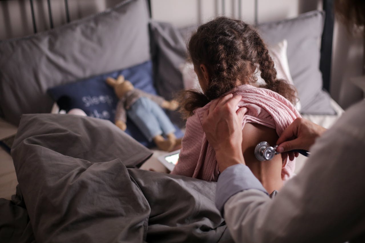 Doctor performing a chest examination on a child patient in a home care setting.