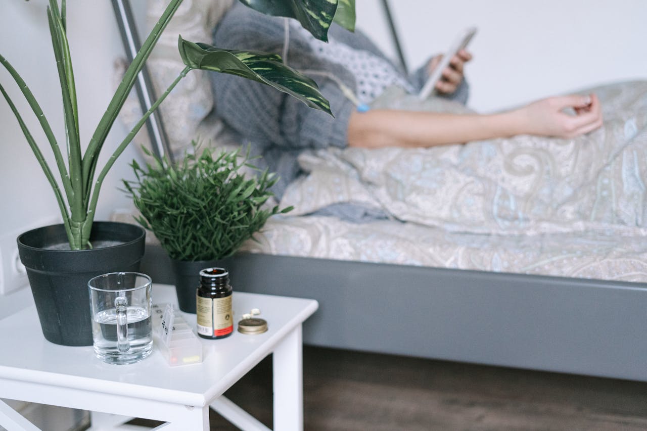 Palliative care nurse sets up bedside meds and water to support home care for a cancer patient