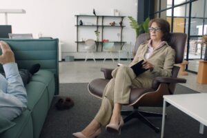 Psychiatrist conducting a therapy session with a patient in a modern office setting.
