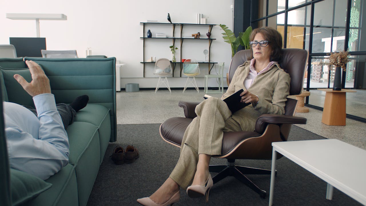 Psychiatrist conducting a therapy session with a patient in a modern office setting.