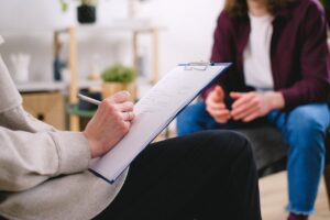 Psychiatrist taking notes during a therapy session with a patient.